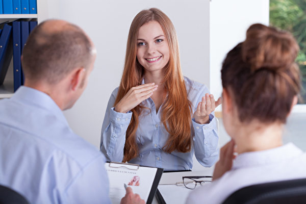 A diverse group of young professionals engaged in a business meeting inside a modern office.